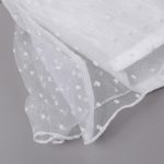 Close-up of a white sheer fabric with small white dots on a gray background.